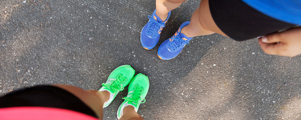 Två par fötter i färgglada joggingskor.