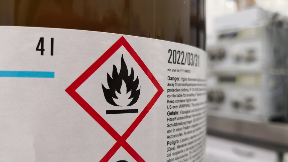 En kemikalieflaska med varningsinformation.